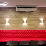 Sofá vermelho com parede de madeira ao fundo